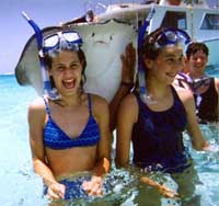 Crystal and Tawnie playing with the stingrays at Stingray City, Sand Bar, Grand Cayman Island
